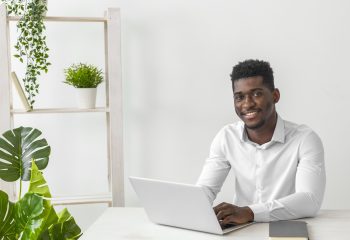 african-american-man-sitting-desk-smiles